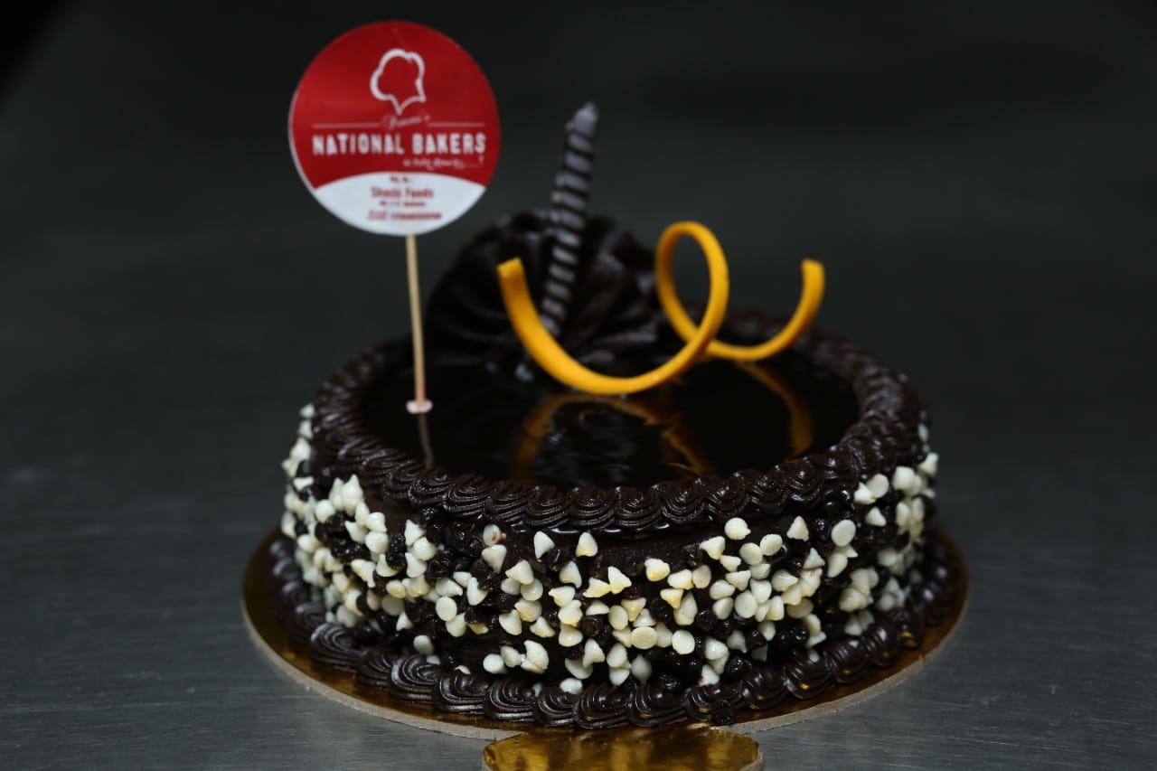 Black & White Choco Cake with layers of dark and white chocolate, decorated with chocolate swirls and shavings, perfect for celebrations.